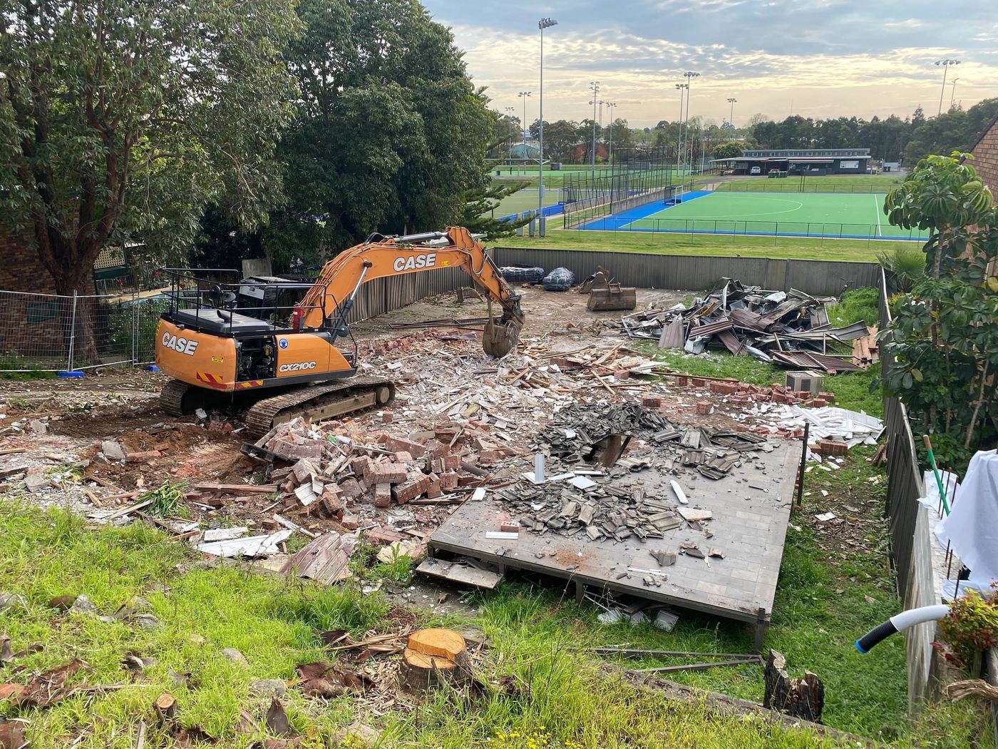 Excavator on a cleared block after a house demolition
